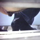 A brief, but complete scene of a woman shitting into a floor toilet as seen from a hidden camera aimed under the toilet stall wall.